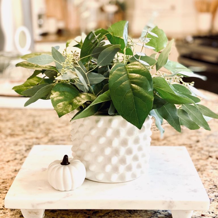 Greenery in white knobby jar