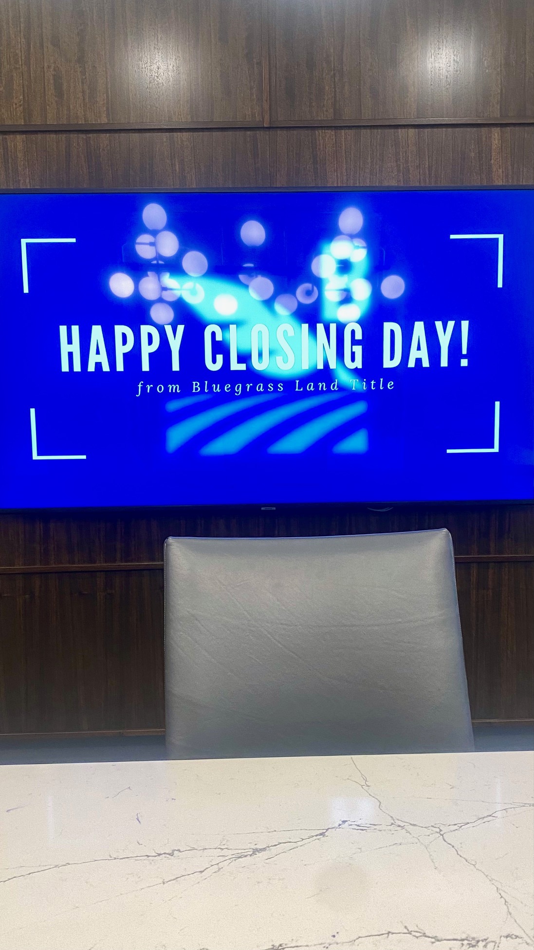 TV in meeting space with the words "Happy Closing Day" written on it.